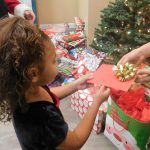 young girl receiving gift at Christmas dinner